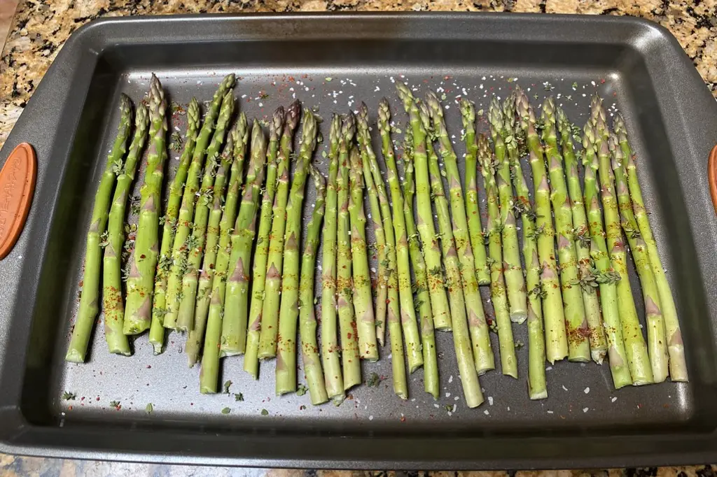 Asparagus spears in a toaster oven baking sheet.