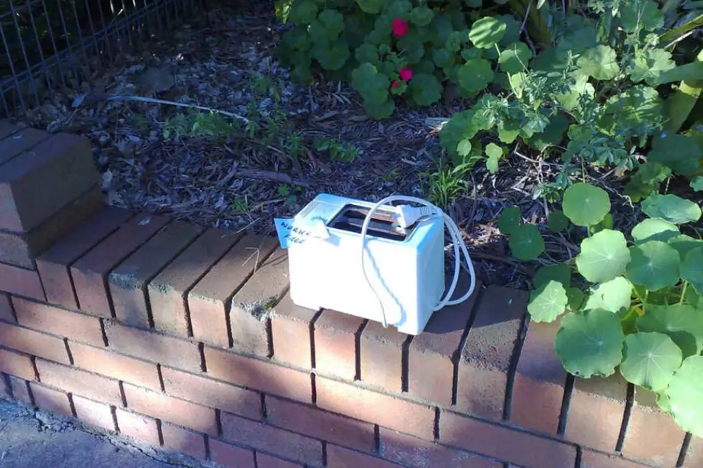 Abandoned toaster with a sticker that reads "works, free".